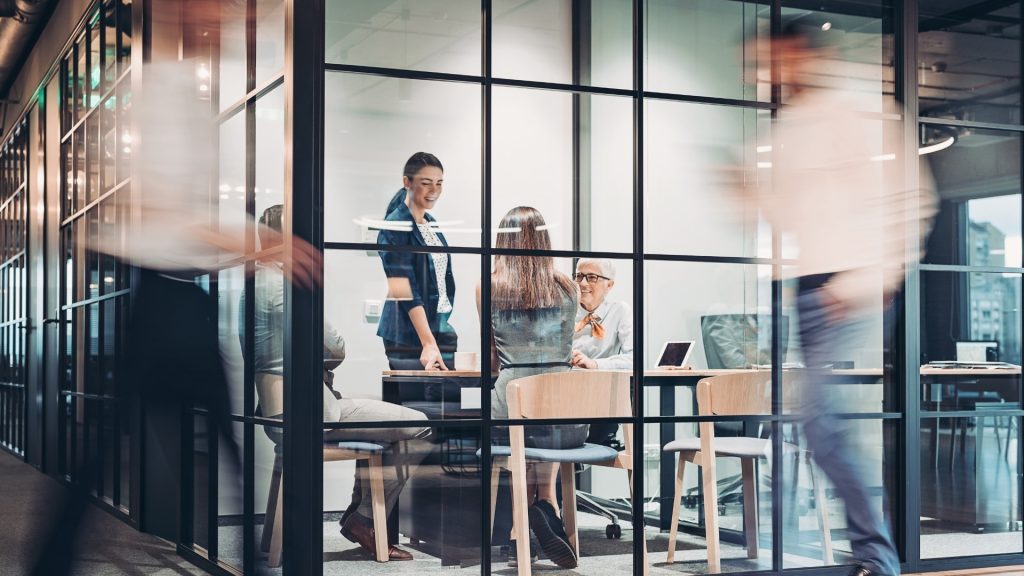 employees in a business meeting in a glass office room