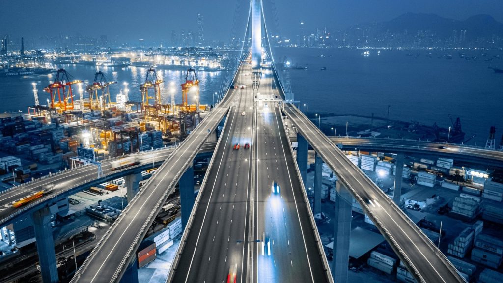 cargo ship port with a highway over it representing international trade and business solutions